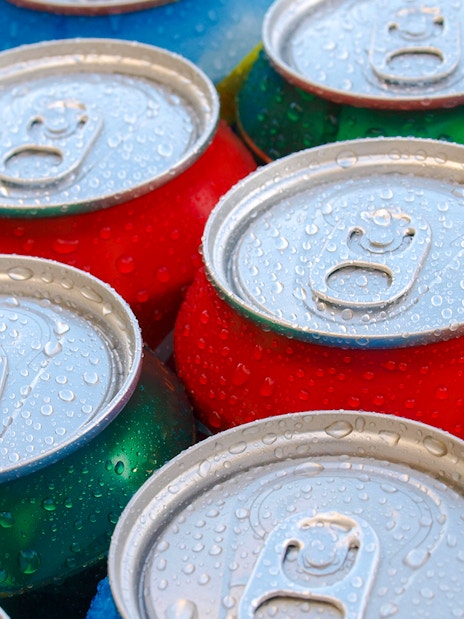 Cold soft drink cans with condensation droplets.