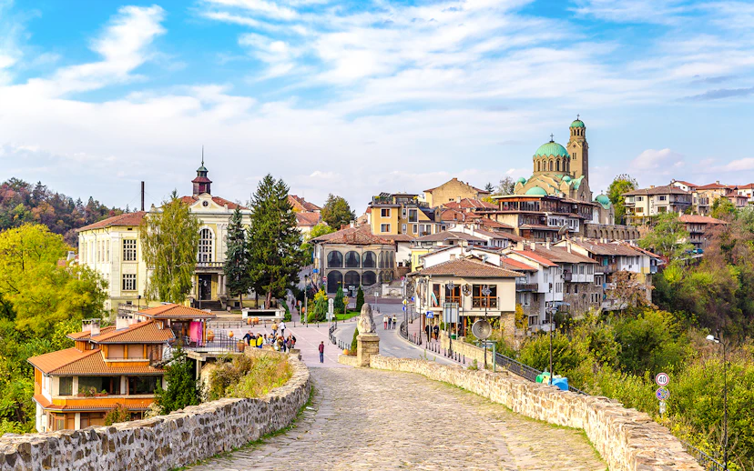 Tsarevets Fortress path leading to Veliko Tarnovo's historic buildings and church.