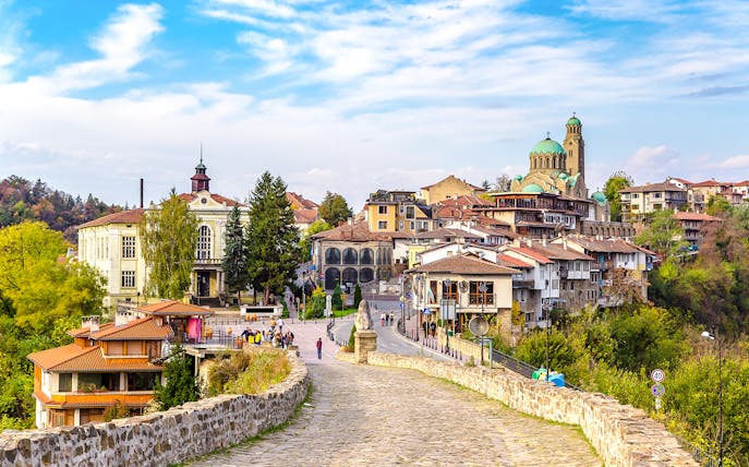 Tsarevets Fortress path leading to Veliko Tarnovo's historic buildings and church.