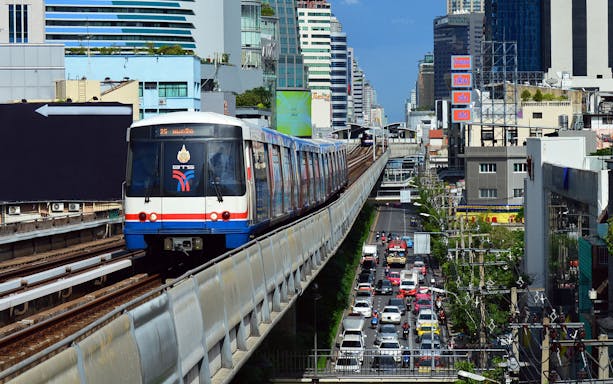 Bangkok BTS Skytrain traveling above city traffic.