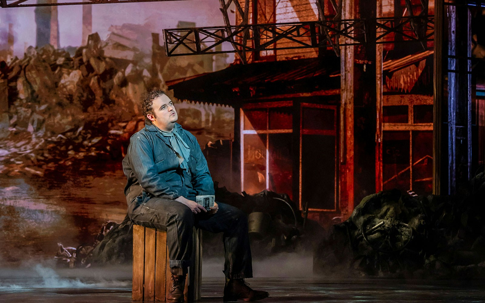 Performer in The Great Gatsby Musical on stage with industrial backdrop.