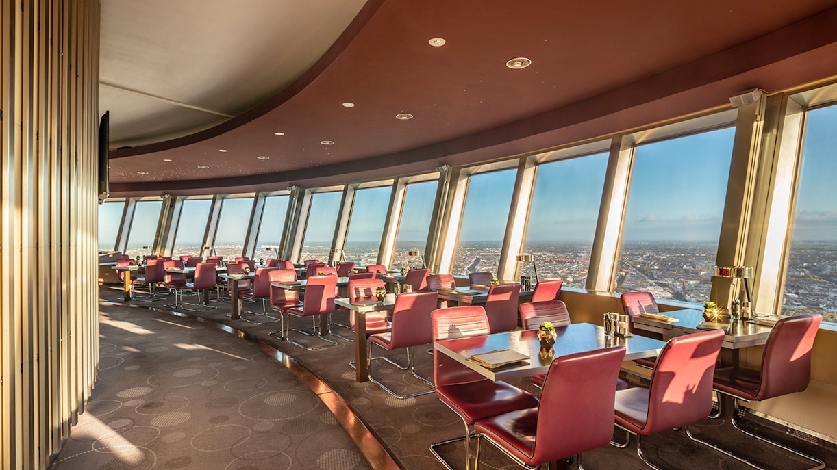 Tables set in the Berlin TV Tower restaurant with panoramic city views.