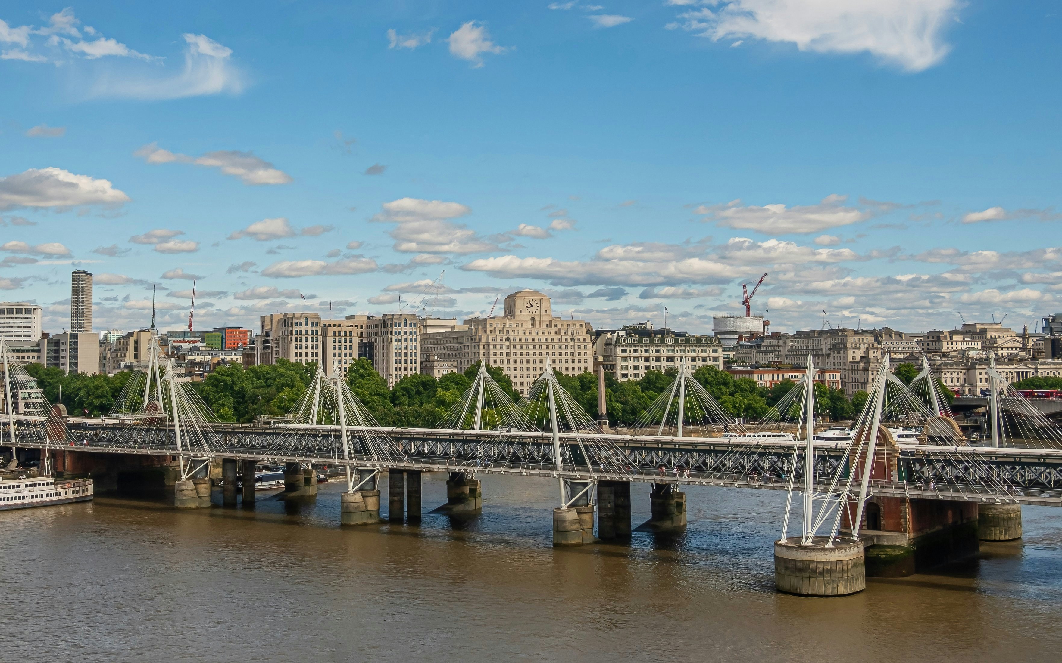 Hungerford Bridge spanning the River Thames with London skyline in the background.