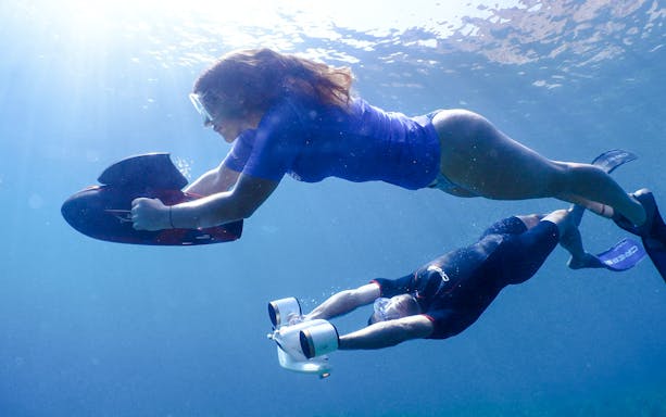 Underwater scooter riders exploring marine life in Marseille.
