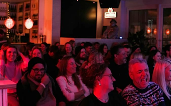 Audience laughing at Hamburg St. Pauli stand-up comedy show.