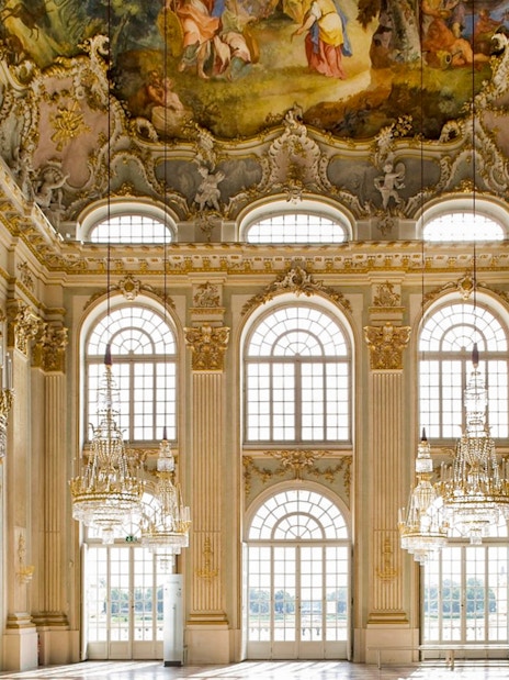 Interior of Nymphenburg Palace's Great Hall with chandeliers and frescoes, Munich City Pass.
