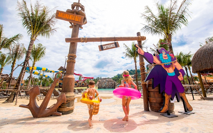 Children entering Andamanda Bay water park in Phuket with colorful floats.