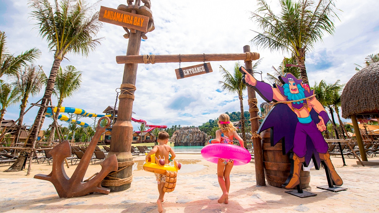 Children entering Andamanda Bay water park in Phuket with colorful floats.