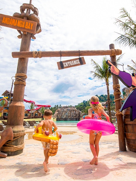 Children entering Andamanda Bay water park in Phuket with colorful floats.