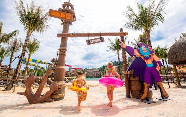 Children entering Andamanda Bay water park in Phuket with colorful floats.