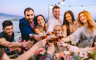Guests toasting with drinks on Athens Riviera cruise with coastal views.