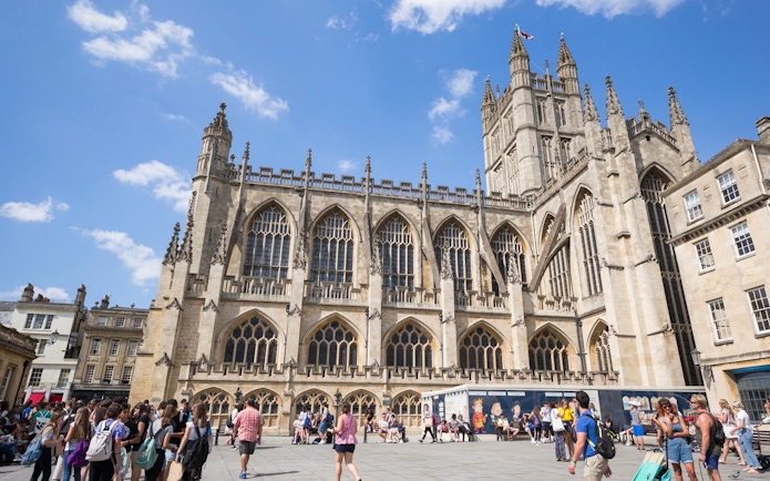 Bath Abbey with tourists in Bath, England, part of the Bridgerton Tour and Bath City Highlights.