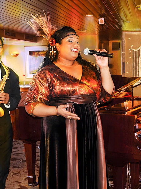 Performers at Nova Five Star 2 with singer, saxophonist, and pianist on stage.