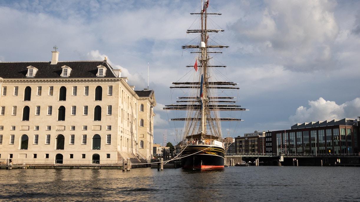 Clipper Stad Amsterdam docked at the National Maritime Museum, Amsterdam, with museum building in view.