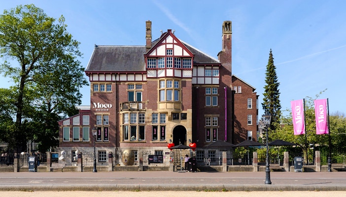 Visitors exploring contemporary art exhibits at Moco Museum, Amsterdam.
