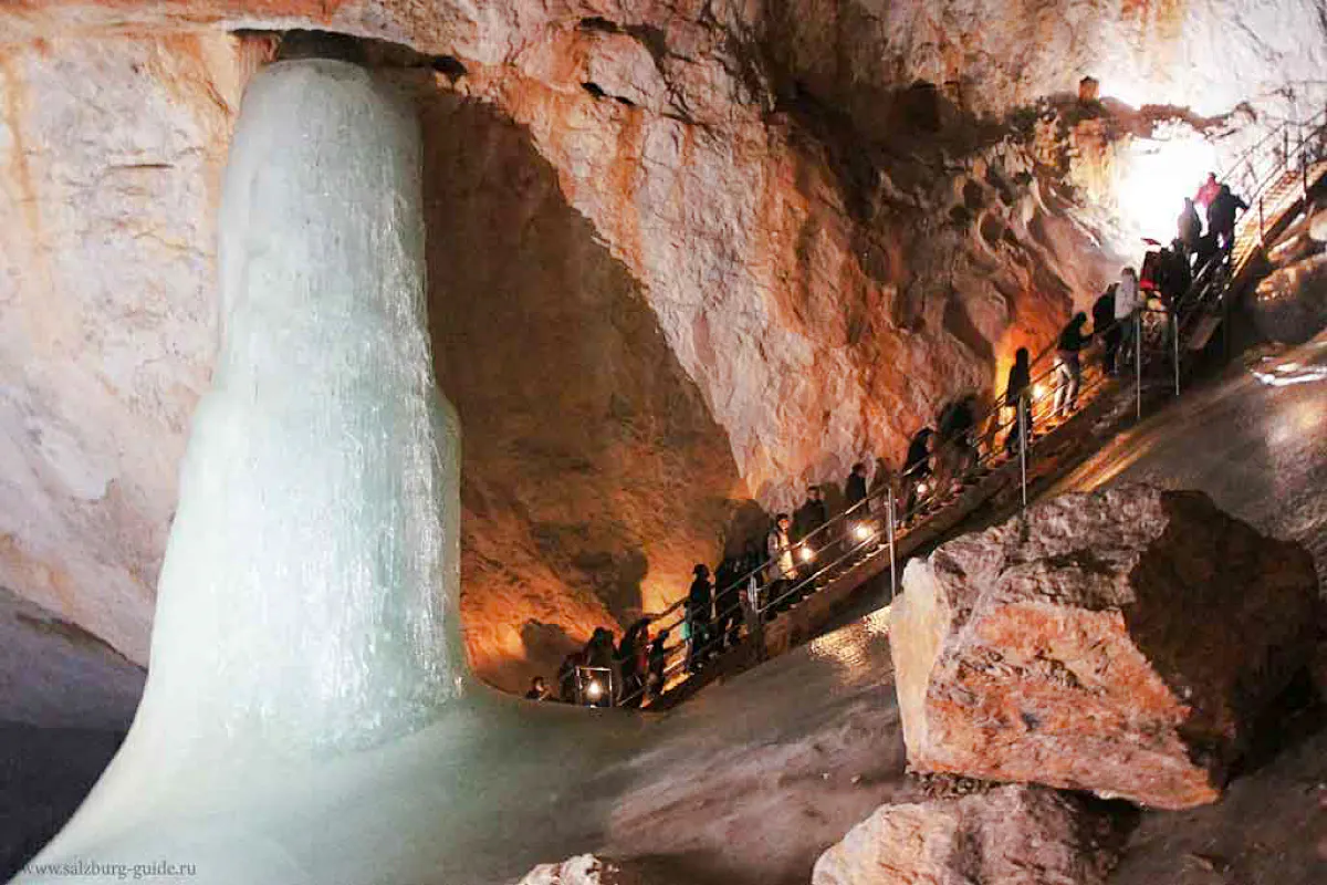 Visitors exploring Werfen Ice Caves with large ice formation, Salzburg trip.