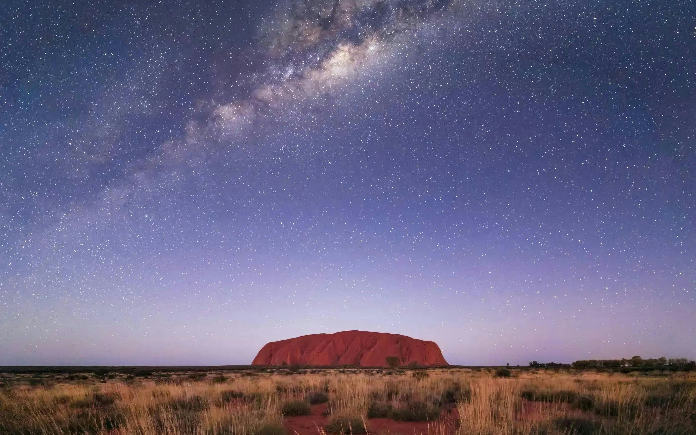 Uluru at sunset with grassland, Northern Territory, Australia.