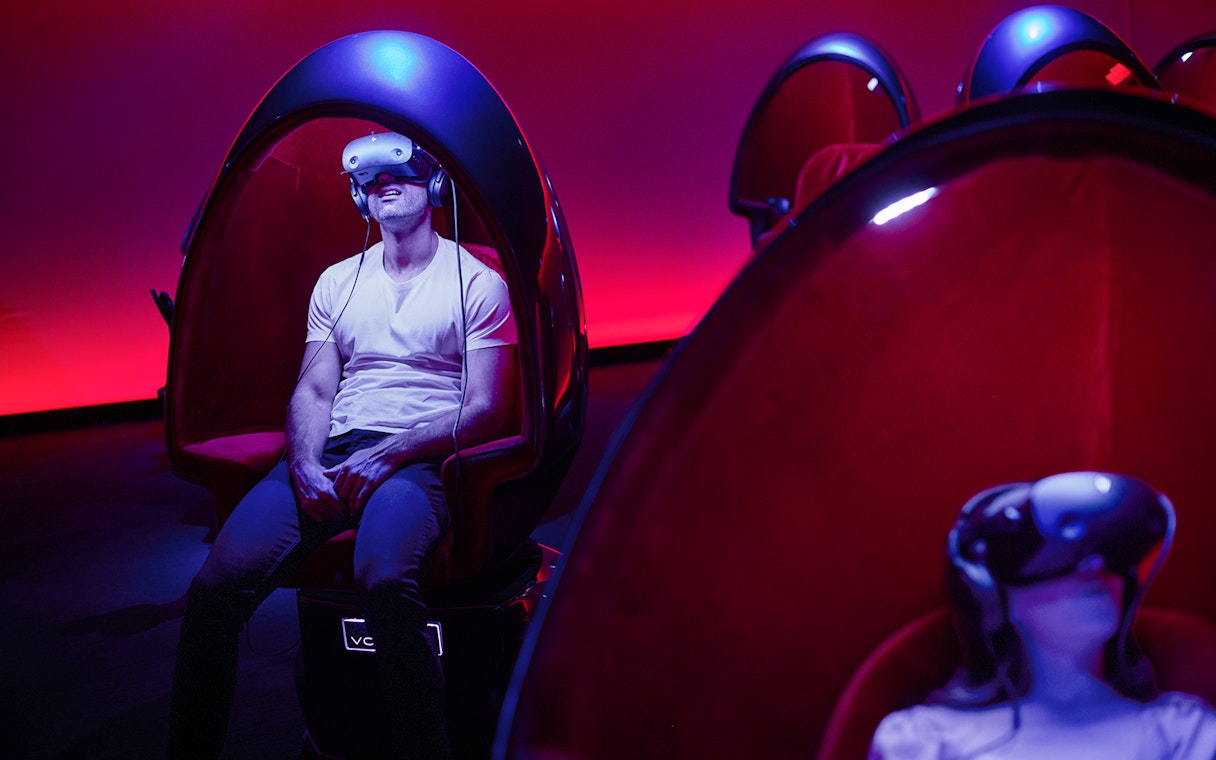 VR experience at Voyager Theatre with person in headset and immersive seating.