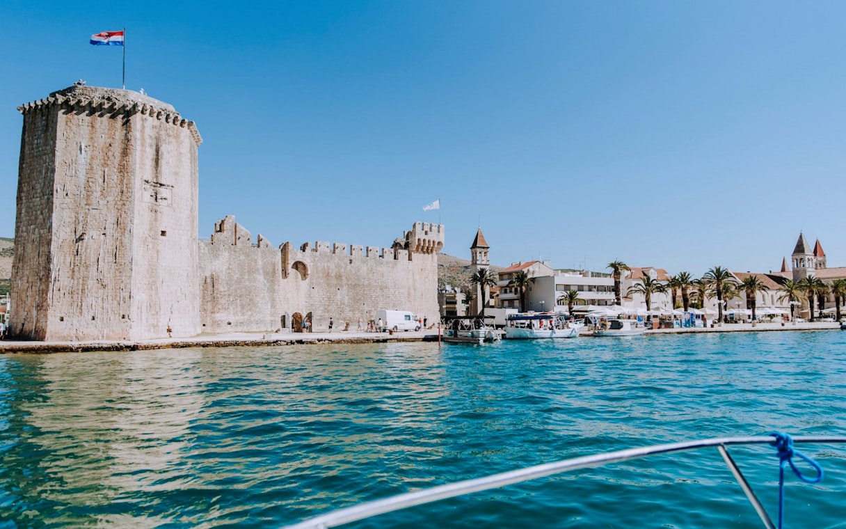 Trogir port view with historic fortress and boats during Blue Lagoon, Solta & Trogir Speedboat Tour.