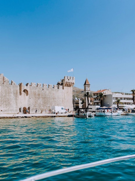 Trogir port view with historic fortress and boats during Blue Lagoon, Solta & Trogir Speedboat Tour.