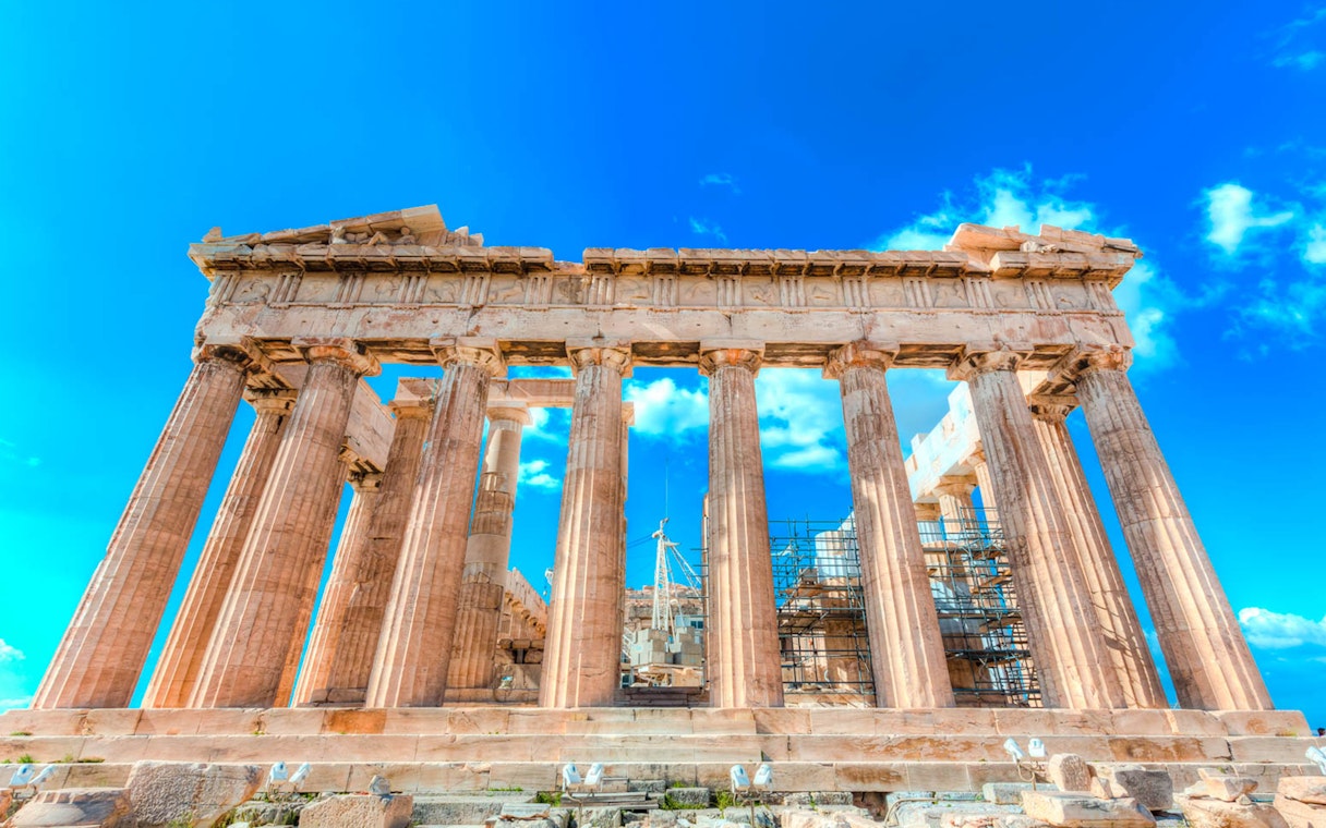 Parthenon temple with scaffolding under a clear blue sky in Athens, Greece.