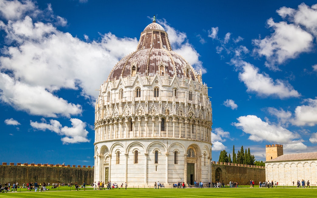 Baptistery in Pisa with tourists on a guided tour.