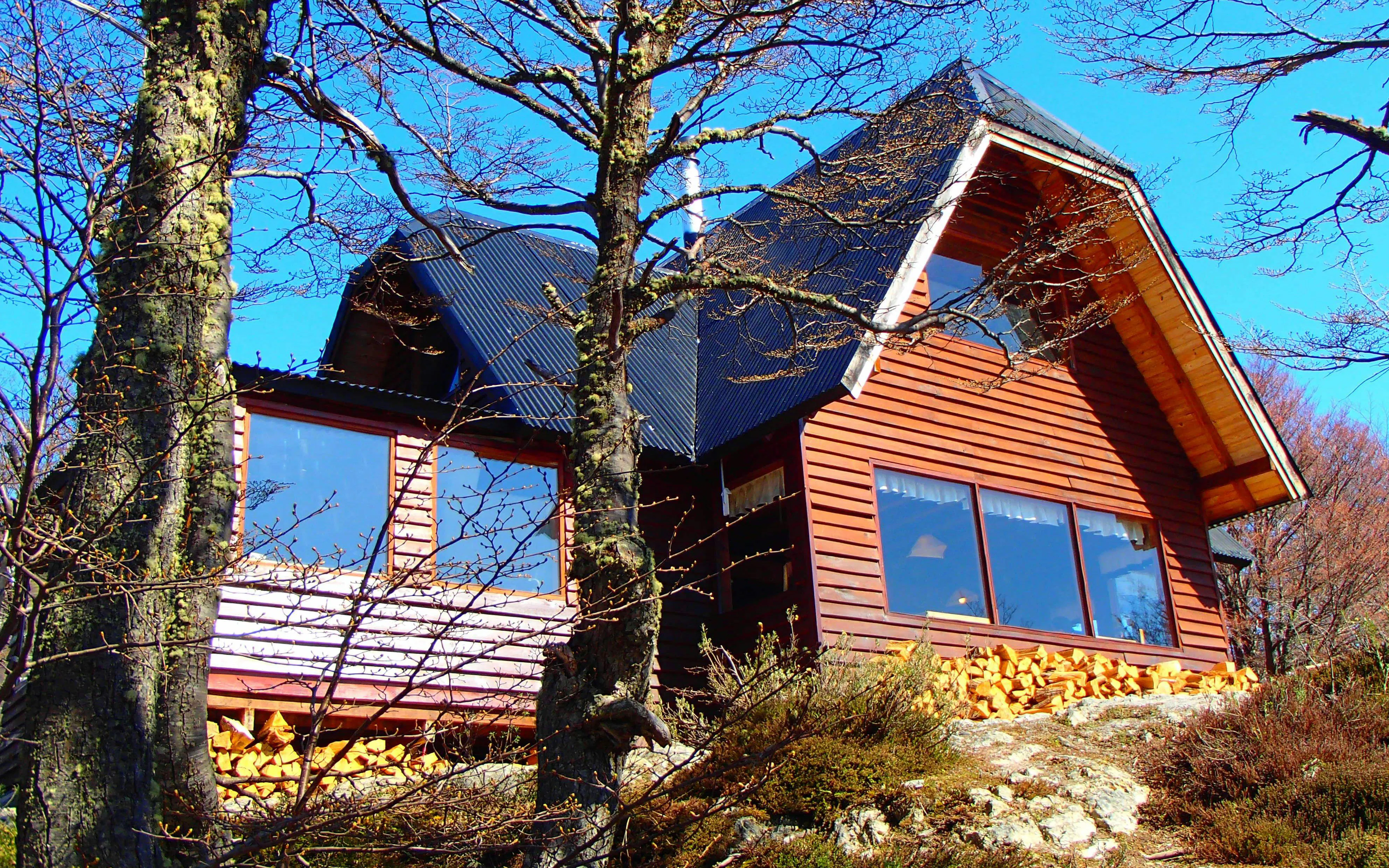 Wooden cabin surrounded by trees, part of the Snow and Fire Night experience.