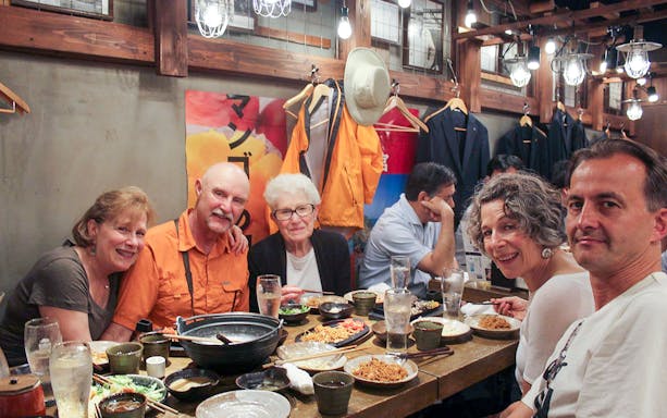 Group enjoying Japanese street food in a Shibuya restaurant.