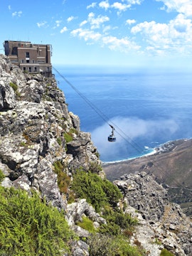 Table Mountain Cable Car ascending with ocean view in Cape Town, South Africa.