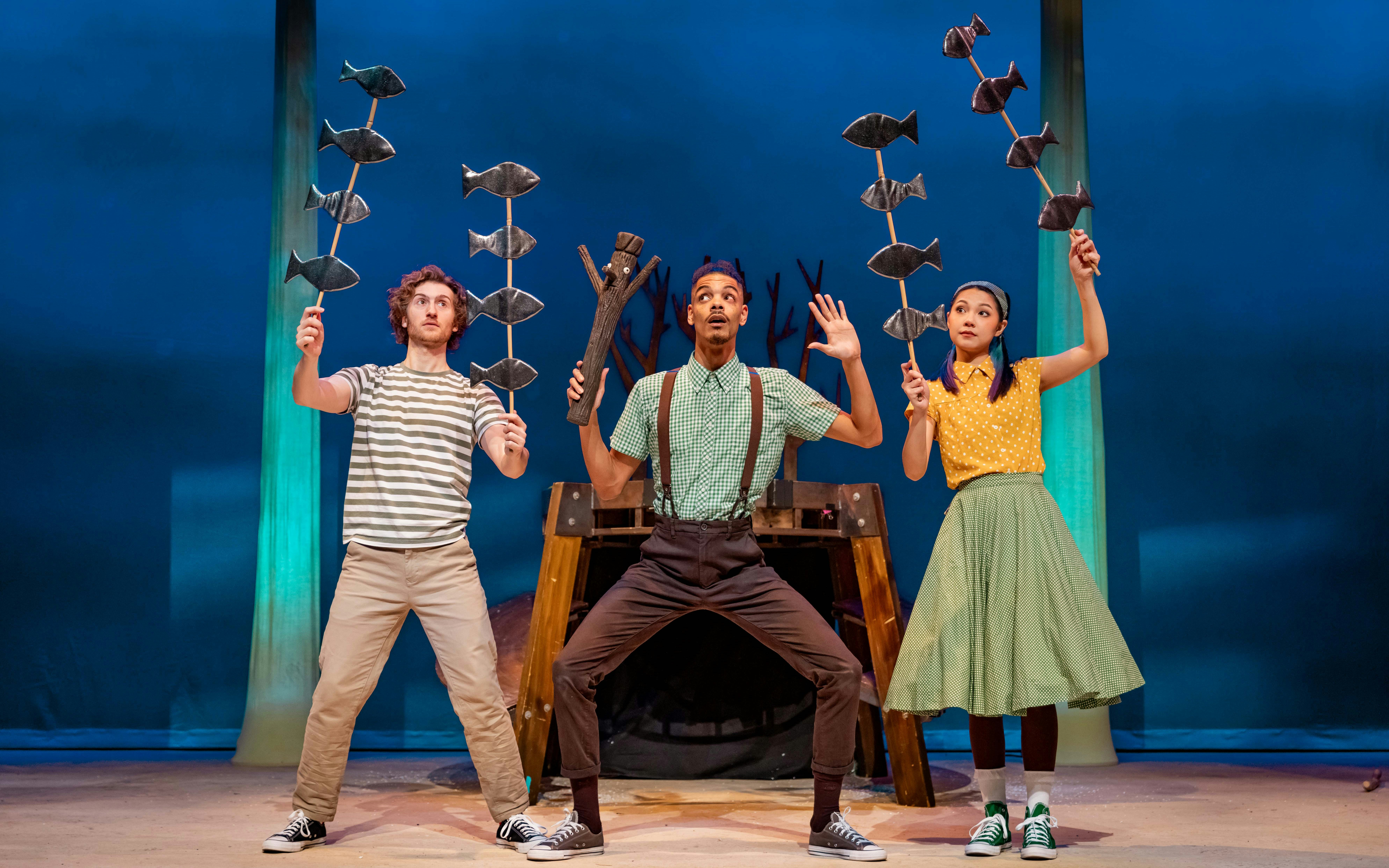 Stage performance of Stick Man in West End with actors holding fish props.