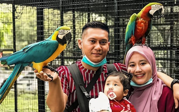 Family with parrots at G2G Animal Garden.