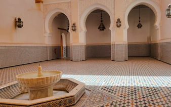 Moroccan courtyard with mosaic tiles and fountain in Meknes.