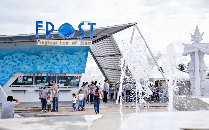 Visitors at Frost Magical Ice of Siam entrance with fountain and statue in Pattaya, Thailand.
