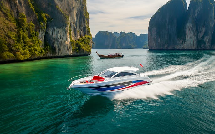 Speedboat cruising near limestone cliffs on Phi Phi Islands tour from Phuket.
