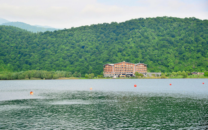 Lake Nohur with a hotel and forested hills in Gabala, Azerbaijan.