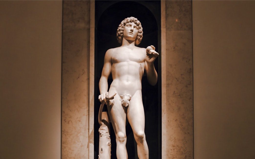 Marble sculpture of Adam by Tullio Lombardo, holding an apple and broken tree branch.