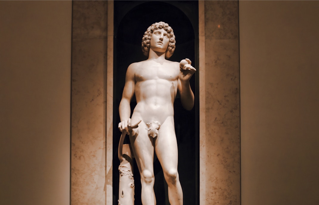 Marble sculpture of Adam by Tullio Lombardo at the Metropolitan Museum of Art, New York, holding an apple and broken tree branch.