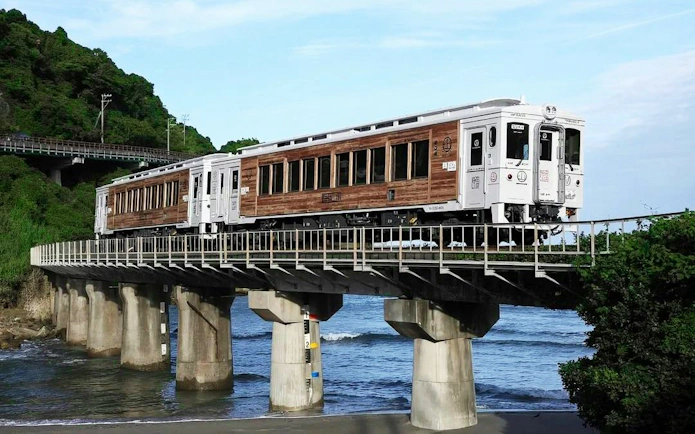 Train crossing a coastal bridge in Kyushu, Japan, part of the JR PASS rail tour.