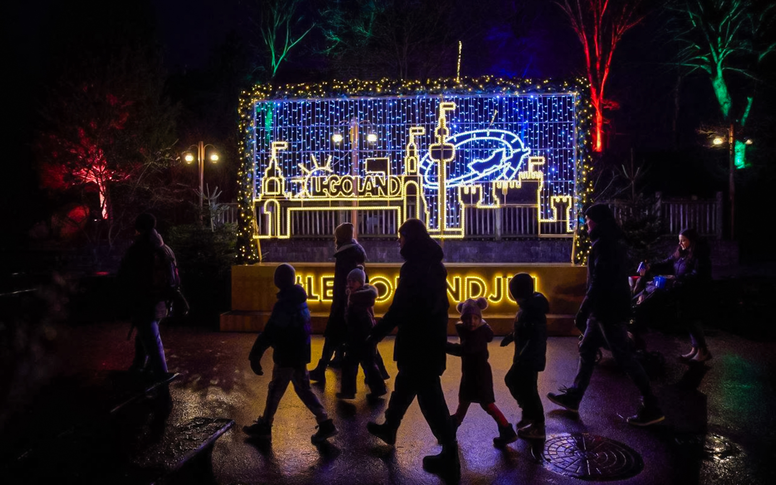 LEGOLAND® Billund Christmas lights display with visitors walking by.