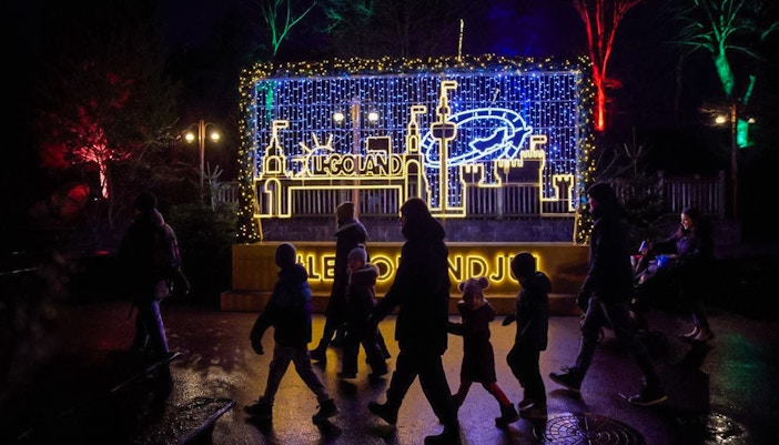 LEGOLAND® Billund Christmas lights display with visitors walking by.