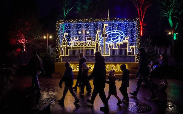 LEGOLAND® Billund Christmas lights display with visitors walking by.