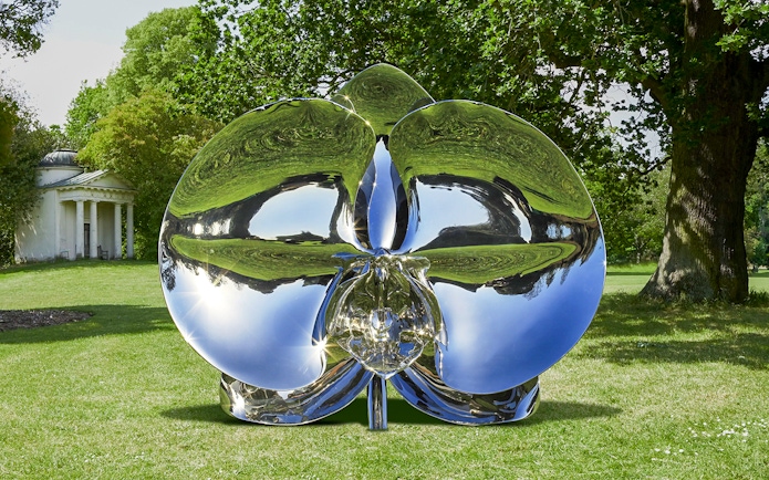 Reflective sculpture "Light of Life" by Marc Quinn in a park setting.