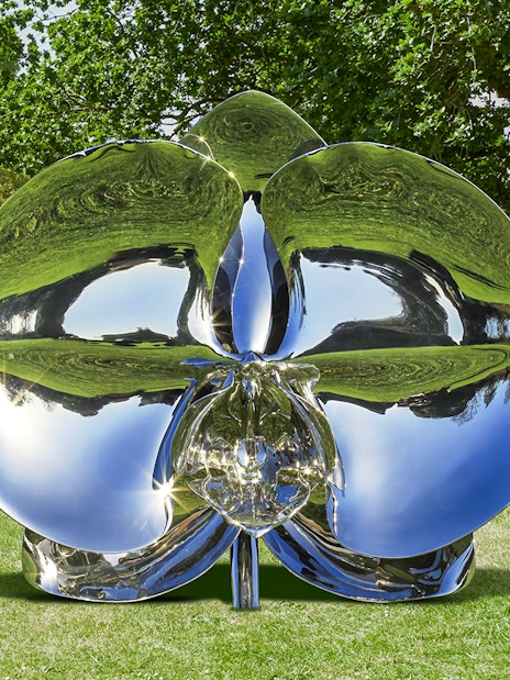 Reflective sculpture "Light of Life" by Marc Quinn in a park setting.