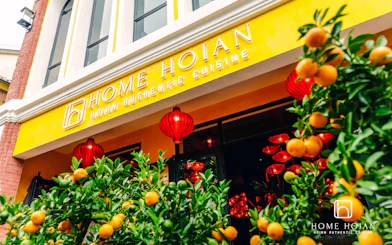 HOME Hoi An Restaurant entrance with red lanterns and citrus plants, Hoi An.
