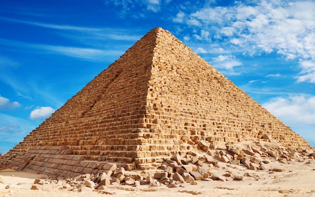 Pyramid of Khufu in Giza under a clear blue sky.