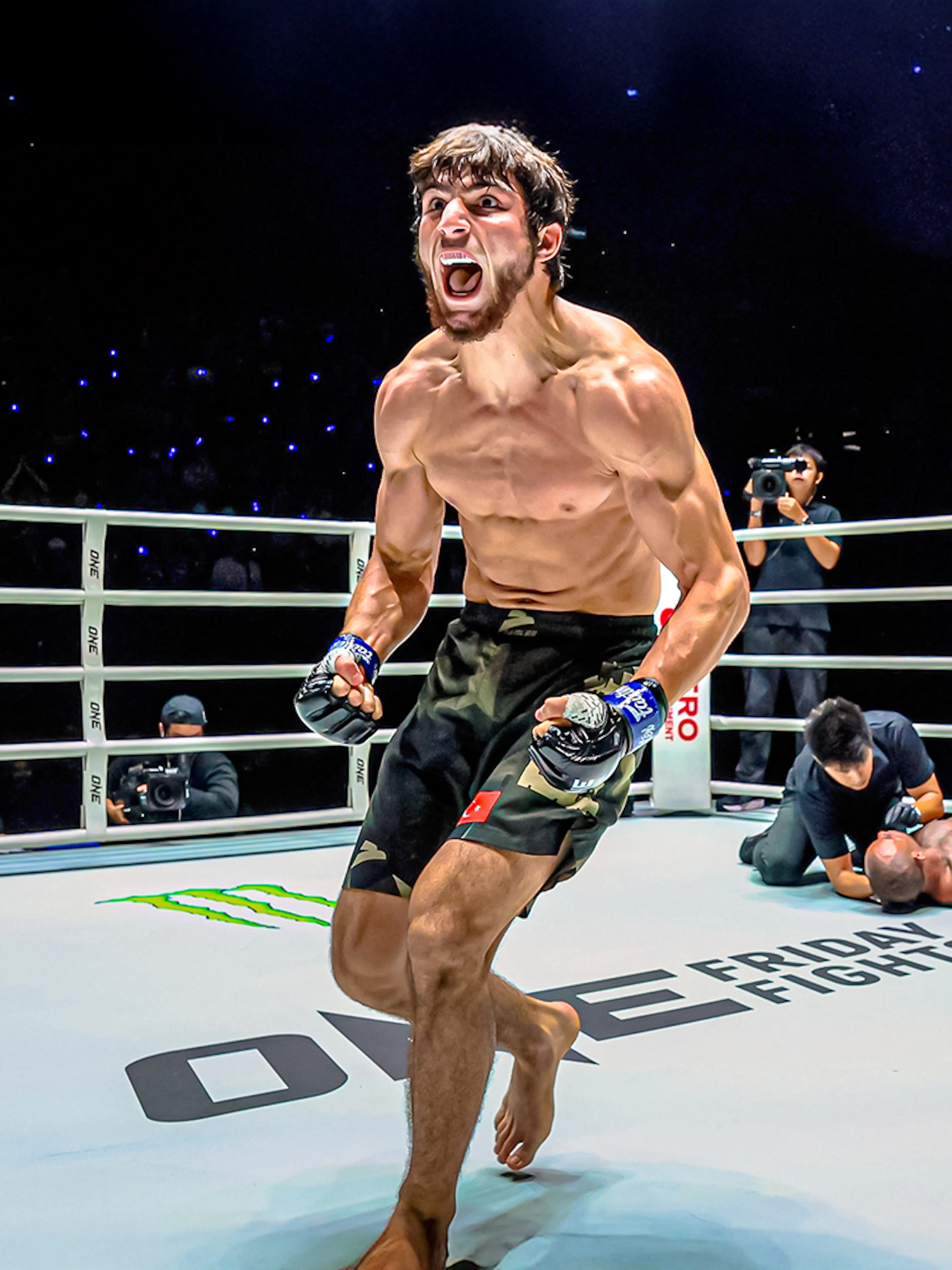 Muay Thai fighter celebrating victory at One Lumpinee Boxing Stadium.