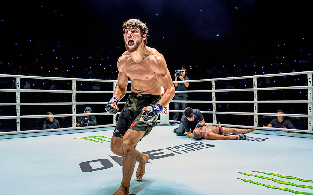 Muay Thai fighter celebrating victory at One Lumpinee Boxing Stadium.