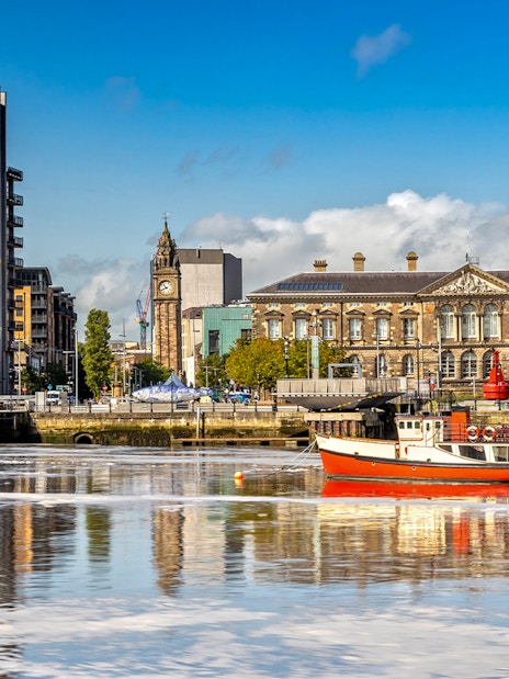 Belfast cityscape with Albert Clock and waterfront buildings.