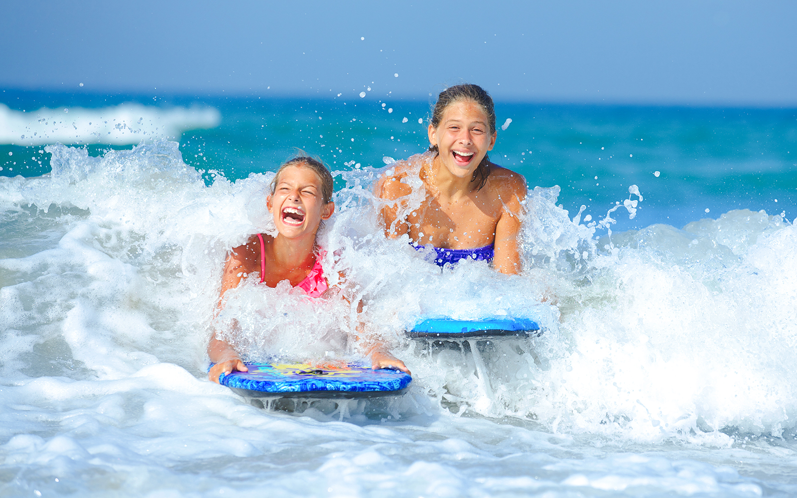Kids enjoying surfing in ocean waves.