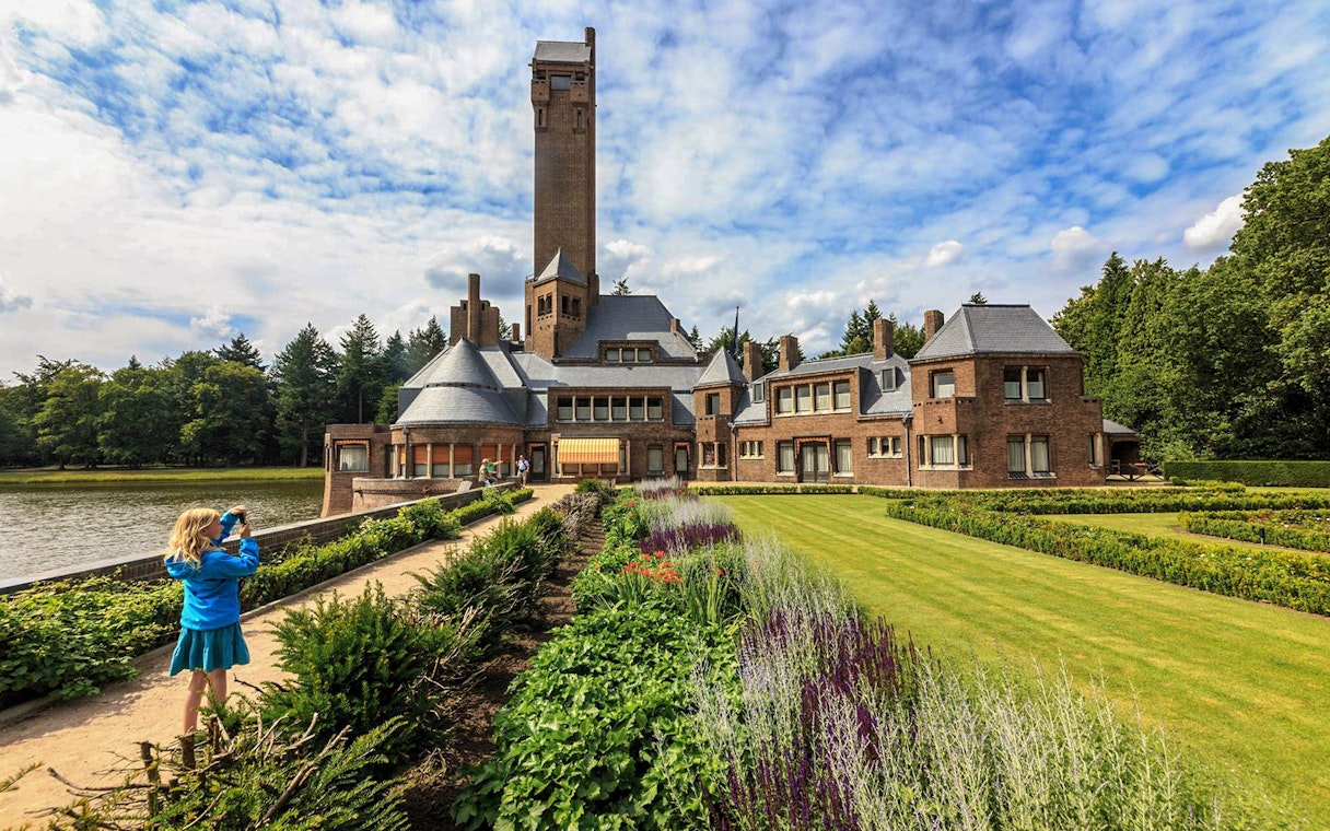 Child photographing Jachthuis Sint Hubertus at Hoge Veluwe National Park, Netherlands.